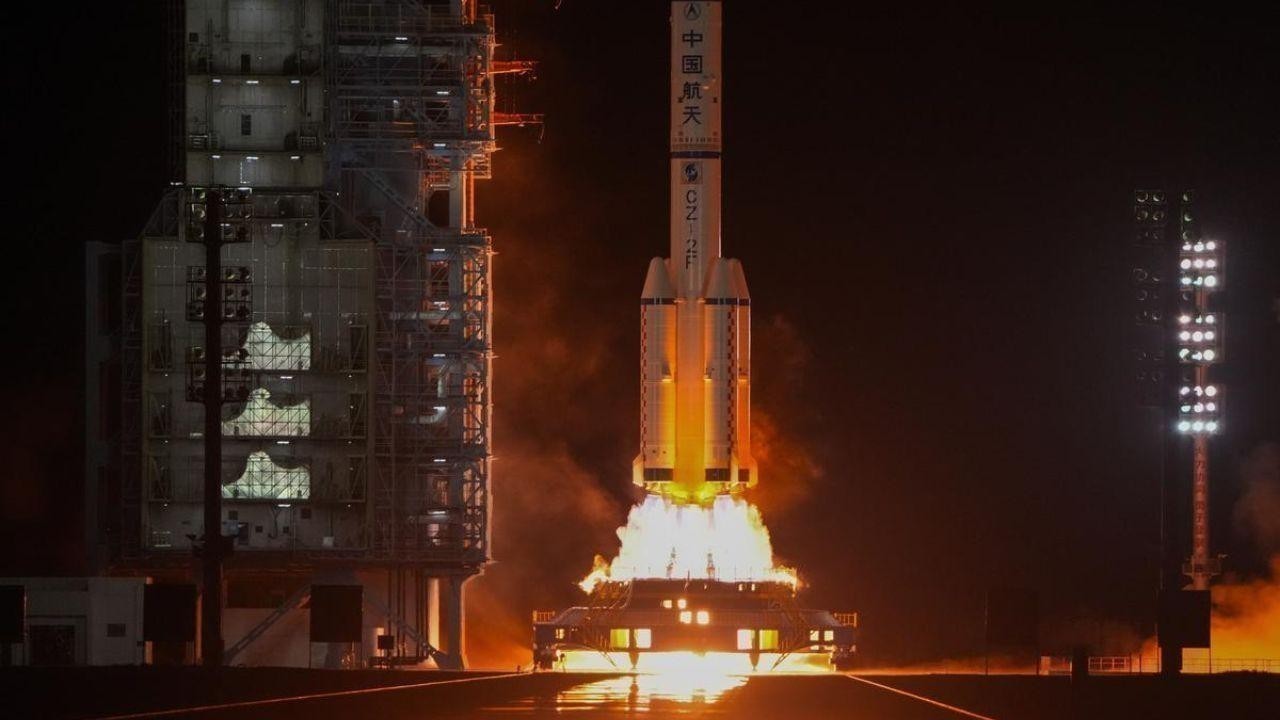 Chinese spacecraft, aiming to land humans on the moon by 2030, takes off with a three-person crew.
